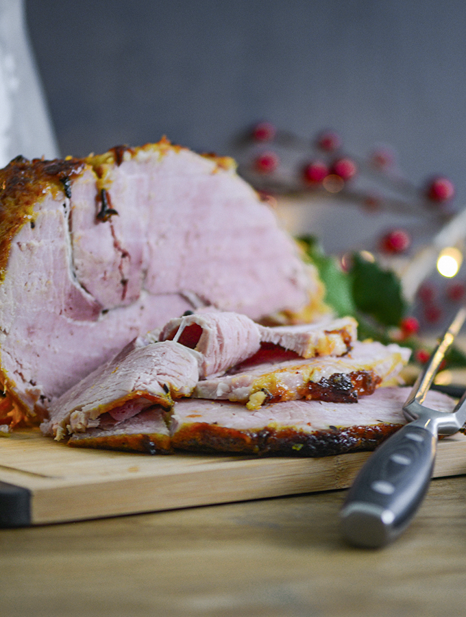 Sliced Christmas glazed ham on a ProCook wooden chopping board